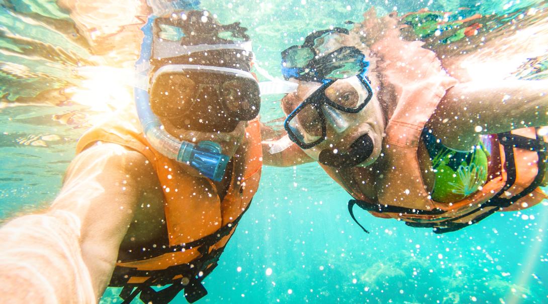 Viajeros nadando en Fiyi. Viajeros realizando snorkel durante sus vacaciones alternativas en Fiyi